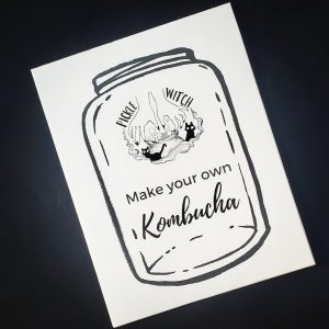 black background with a white zine cover at an angle showing an illustrated jar and lettering