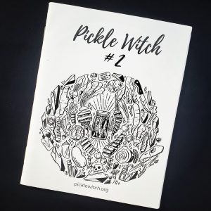 white zine cover on black background with a circular illustration on the front